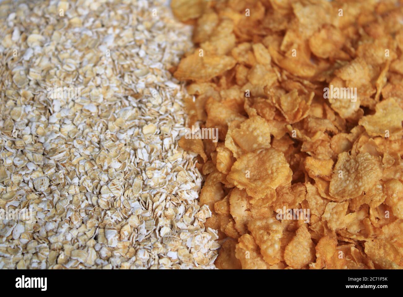 Voller Hafer und Cornflakes. Haferbrei in Getreide und Cornflakes auf weißem Hintergrund. Gesunde Ernährung Konzept-Haferflocken und Cornflakes. Stockfoto