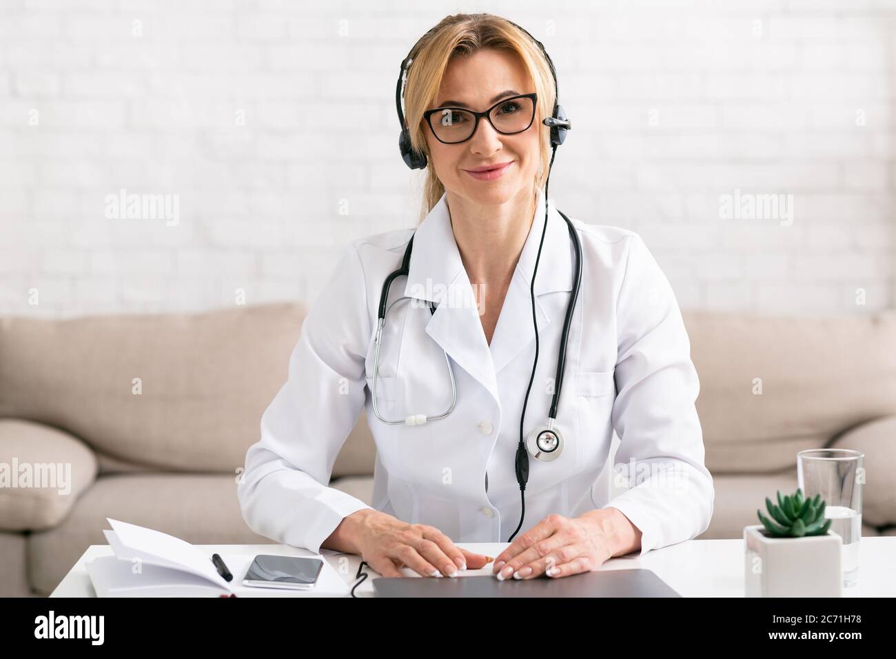 Online-medizinische Beratung, zu Hause bleiben. Arzt am Arbeitsplatz mit Laptop Stockfoto