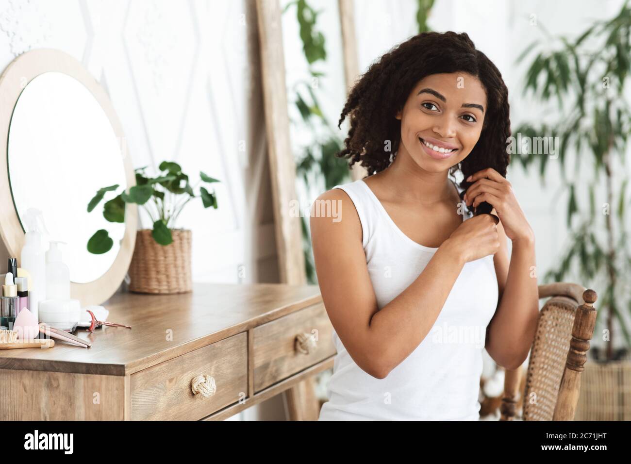 Self-Care Und Wellness-Konzept. Glücklich Schwarze Frau Genießen Berühren Sie Schön Haar Stockfoto