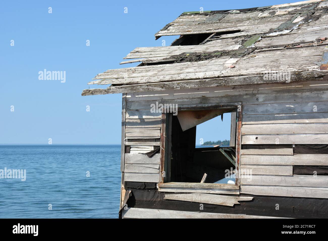 Verlassene Fischerhütte mit Blick auf Lake Superior durch das Fenster. Stockfoto