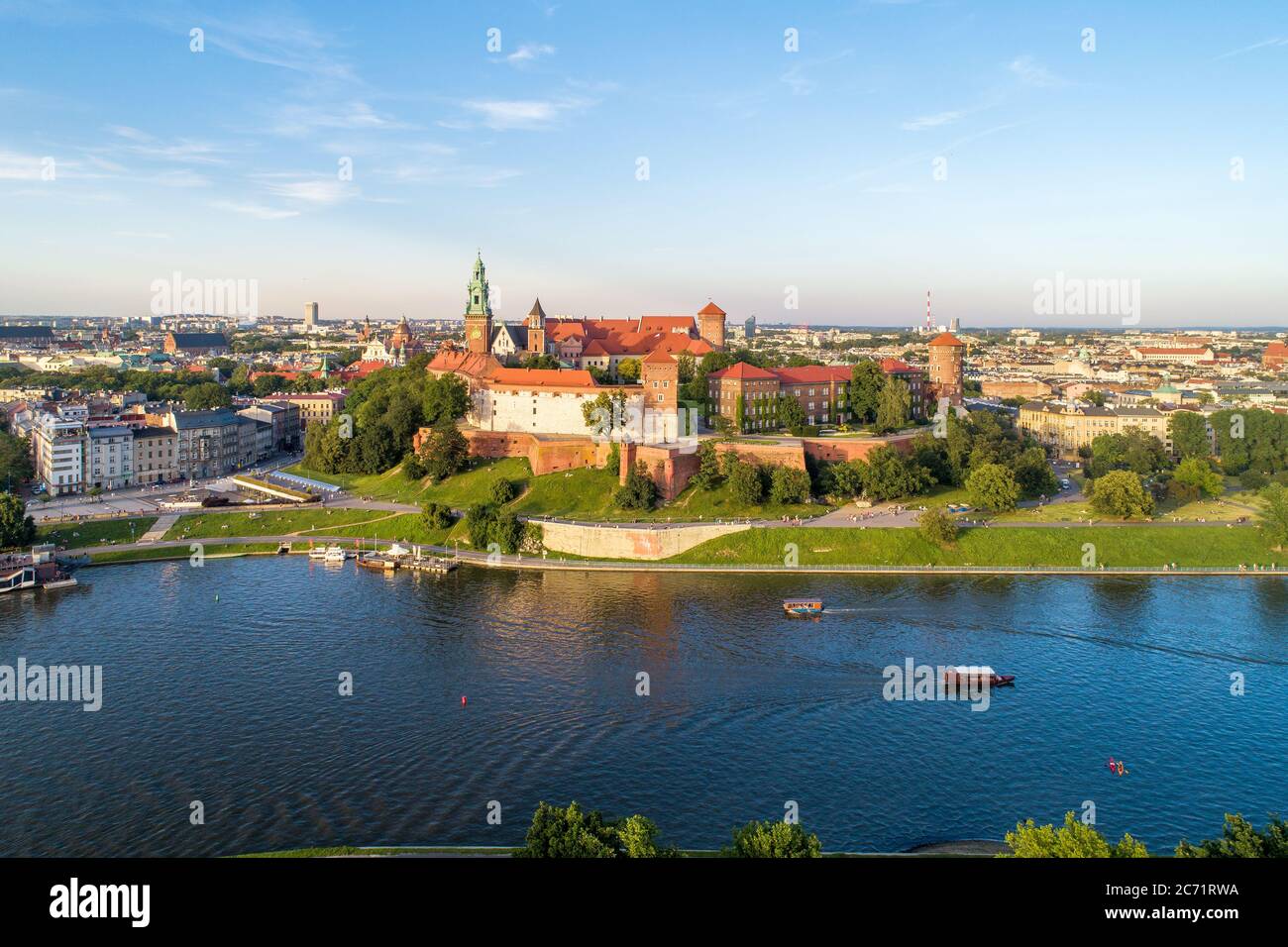 Königliche Wawel-Kathedrale und Schloss in Krakau, Polen. Luftaufnahme bei Sonnenuntergang. Weichsel, Touristenboote, Kanus, Flussufer mit Park. Promenade Stockfoto
