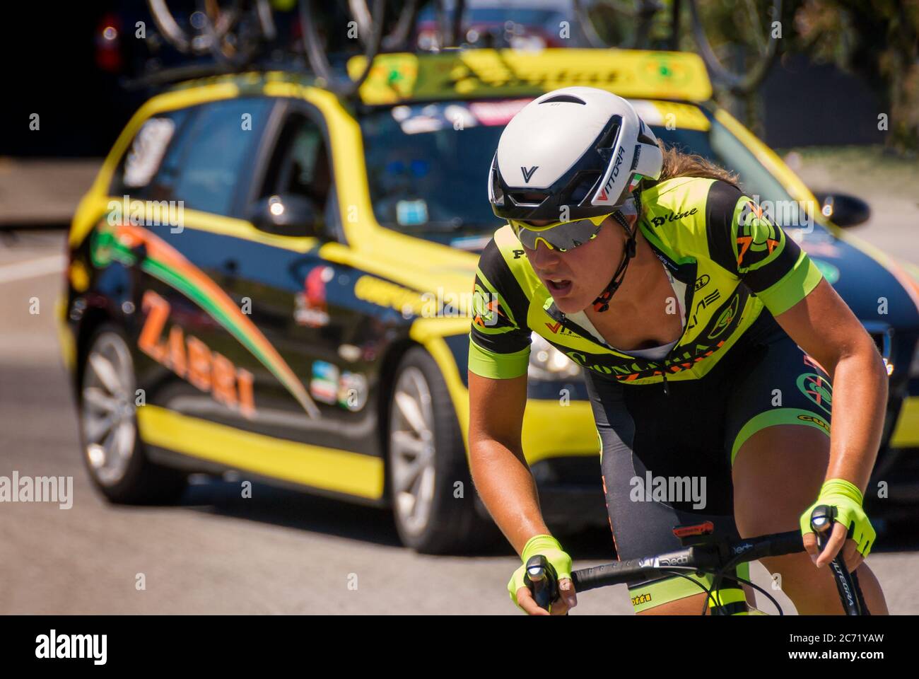 RIVAROLO CANAVESE, ITALIEN - JUNI 2017: Radfahrerin in gelb und schwarz, gefolgt von einem Assistenzauto während der italienischen Straßenradmeisterinnen Stockfoto