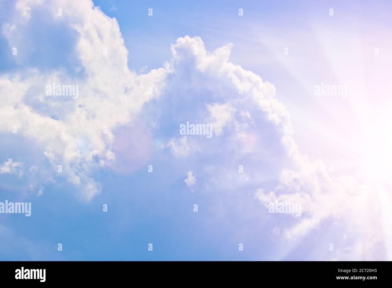 Cumulus Wolken am blauen Himmel und Sonnenstrahlen brechen durch die Wolken. Speicherplatz kopieren Stockfoto