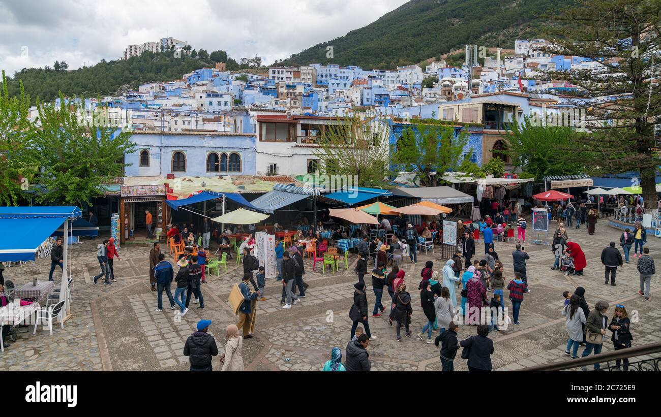 Chefchaouen, Marokko - April 2018: Chefchaouen Medina mit unbekannten Menschen, blaue Skyline der Stadt auf dem Hügel, Marokko Stockfoto