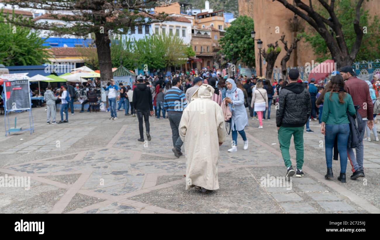 Chefchaouen, Marokko - April 2018: Chefchaouen Medina mit unbekannten Menschen, blaue Skyline der Stadt auf dem Hügel, Marokko Stockfoto