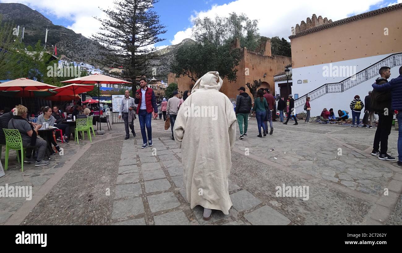 Chefchaouen, Marokko - April 2018: Chefchaouen Medina mit unbekannten Menschen, blaue Skyline der Stadt auf dem Hügel, Marokko Stockfoto
