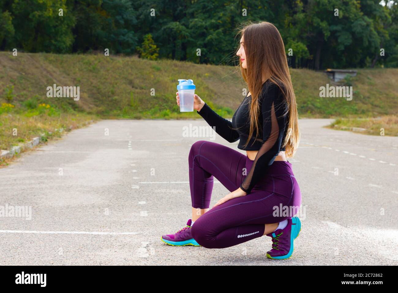 Schöne junge Mädchen in Lauftraining mit Wasser. Frau Athletin macht eine Pause, um Wasser zu trinken. Sommertraining. Fitness, Menschen und gesunde livestyl Stockfoto