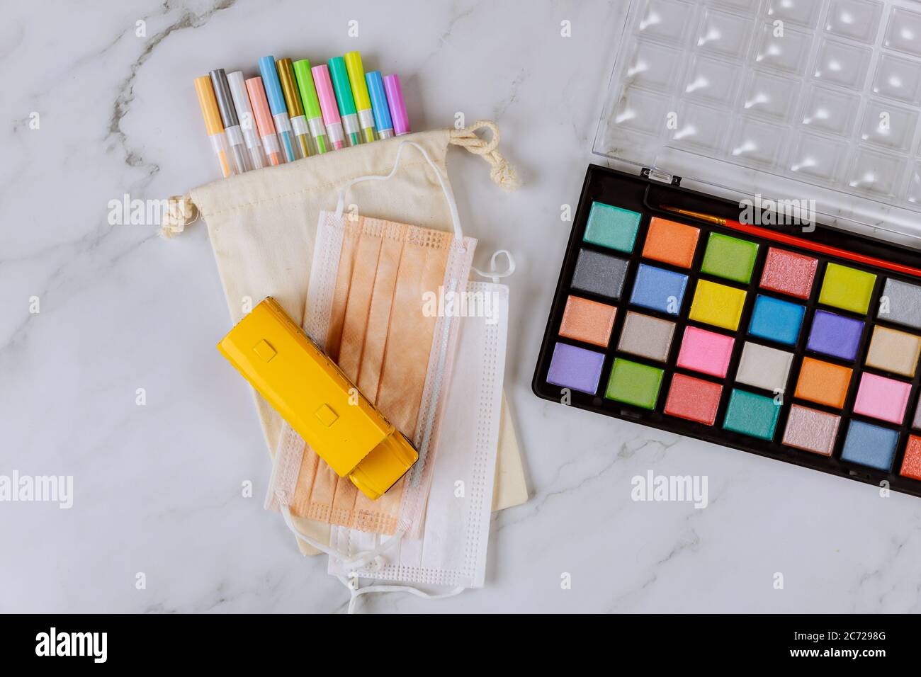 Farbige Farbe mit Stiften und Gesichtsmaske. Pandemie zurück zur Schule. Stockfoto