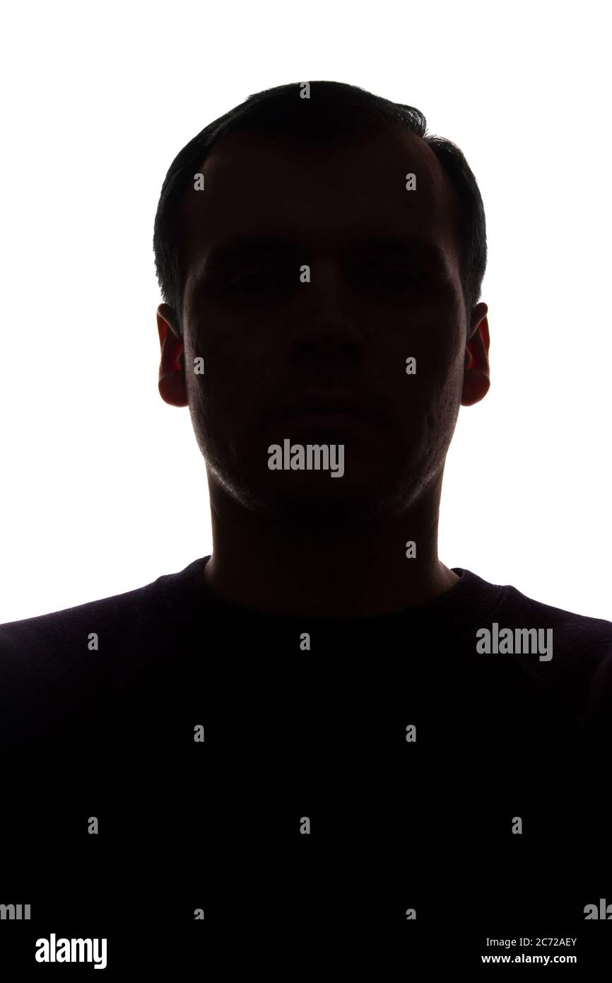 Porträt eines jungen Mannes, unrasiert, Vorderansicht - dunkel isoliert Silhouette Stockfoto