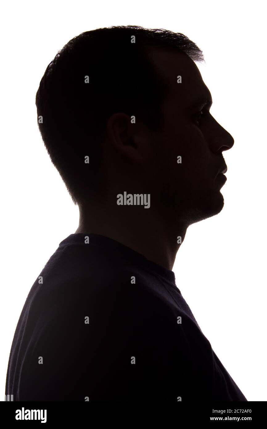 Porträt eines jungen Mannes, unrasiert, Seitenansicht - dunkel isoliert Silhouette Stockfoto
