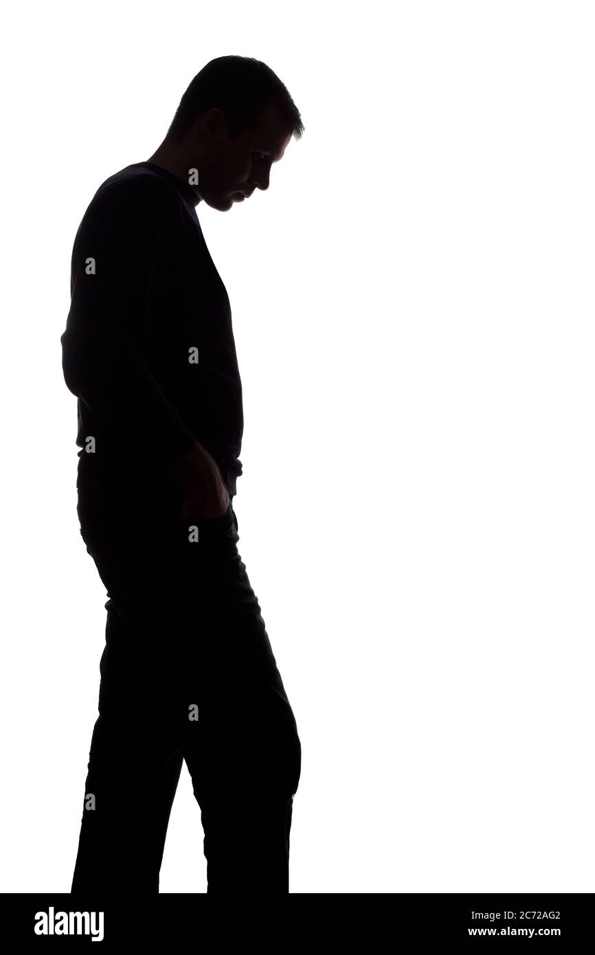 Porträt eines jungen Mannes, unrasiert, Seitenansicht - dunkel isoliert Silhouette Stockfoto