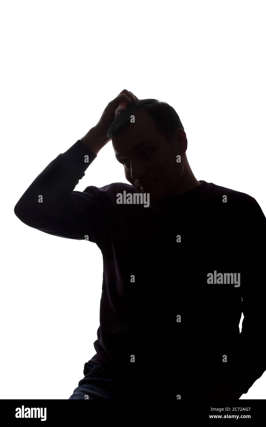 Porträt eines jungen Mannes, unrasiert, Vorderansicht - dunkel isoliert Silhouette Stockfoto