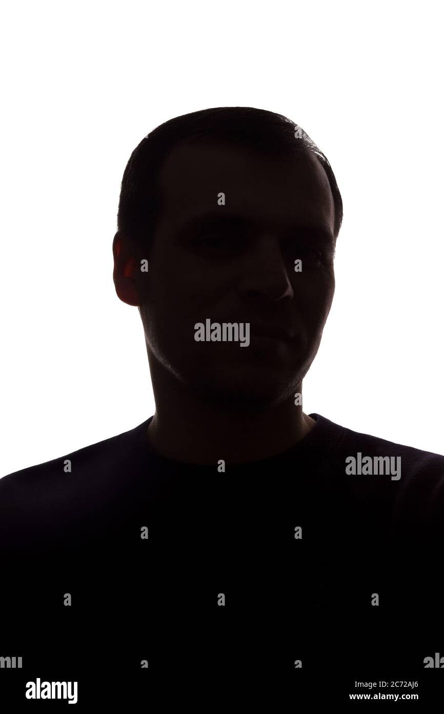 Porträt eines jungen Mannes, unrasiert, Vorderansicht - dunkel isoliert Silhouette Stockfoto