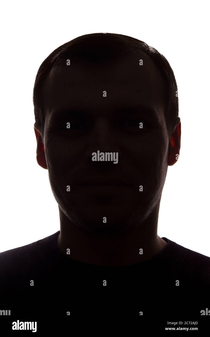 Porträt eines jungen Mannes, unrasiert, Vorderansicht - dunkel isoliert Silhouette Stockfoto