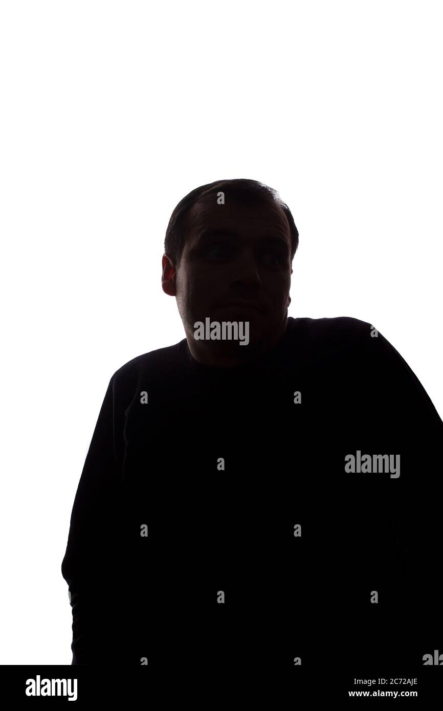 Porträt eines jungen Mannes, unrasiert, Vorderansicht hob seinen Zeigefinger nach oben Idee - dunkel isoliert Silhouette Stockfoto