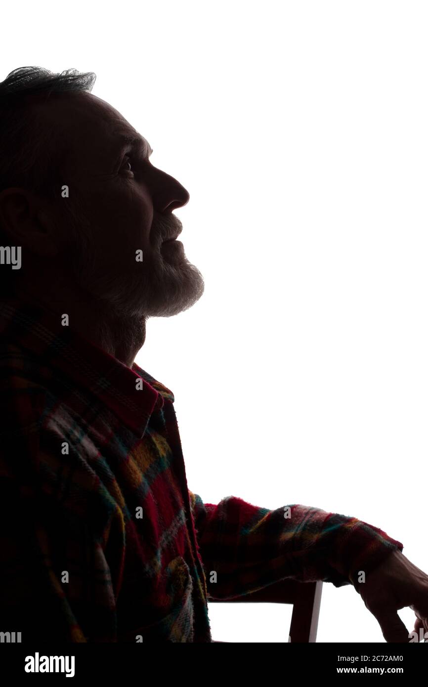 Porträt eines alten Mannes, unrasiert, mit Bart, Seitenansicht - dunkel isolierte Silhouette Stockfoto