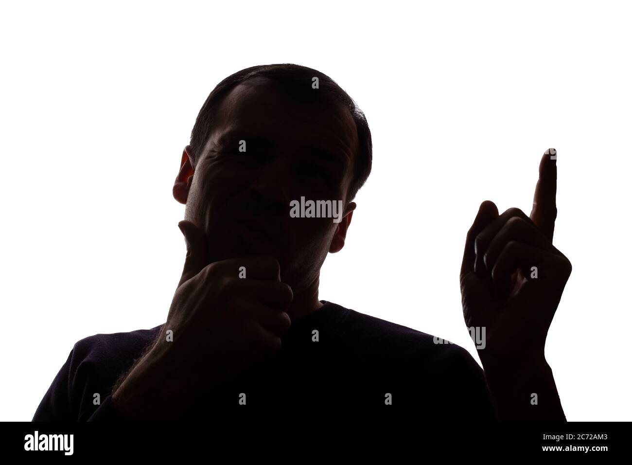 Porträt eines jungen Mannes, unrasiert, Vorderansicht hob seinen Zeigefinger nach oben Idee - dunkel isoliert Silhouette Stockfoto