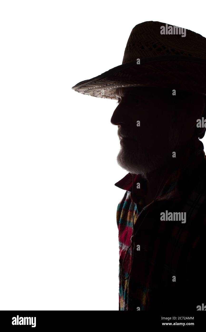 Porträt eines alten Mannes, in einem Cowboy-Hut, mit Bart, Seitenansicht - dunkel isoliert Silhouette Stockfoto