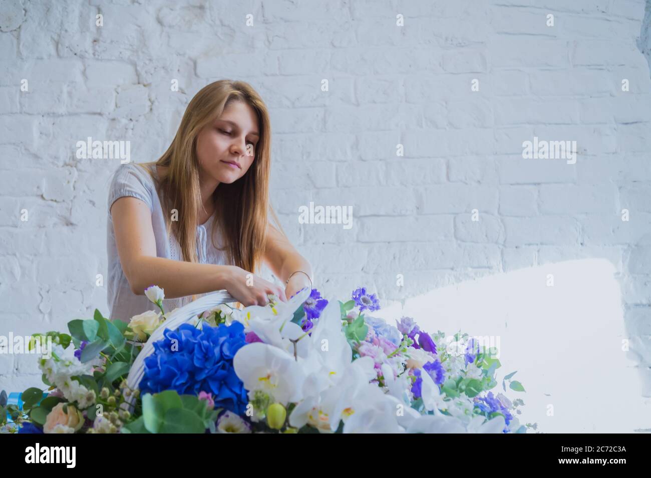 Portrait von professionellen Frau floral Künstler, Floristen machen große Blumenkorb mit Blumen in der Werkstatt, Blumenladen. Floristik, Handarbeit, Hochzeit Stockfoto