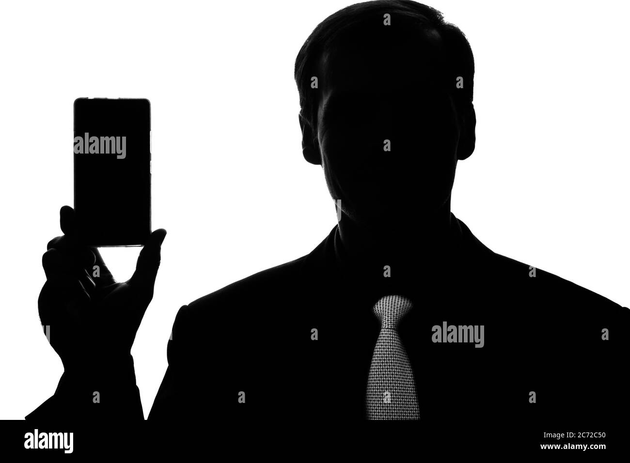 Portrait junger Geschäftsmann im Anzug, Krawatte mit Smartphone, Tablet in der Hand - Silhouette Stockfoto
