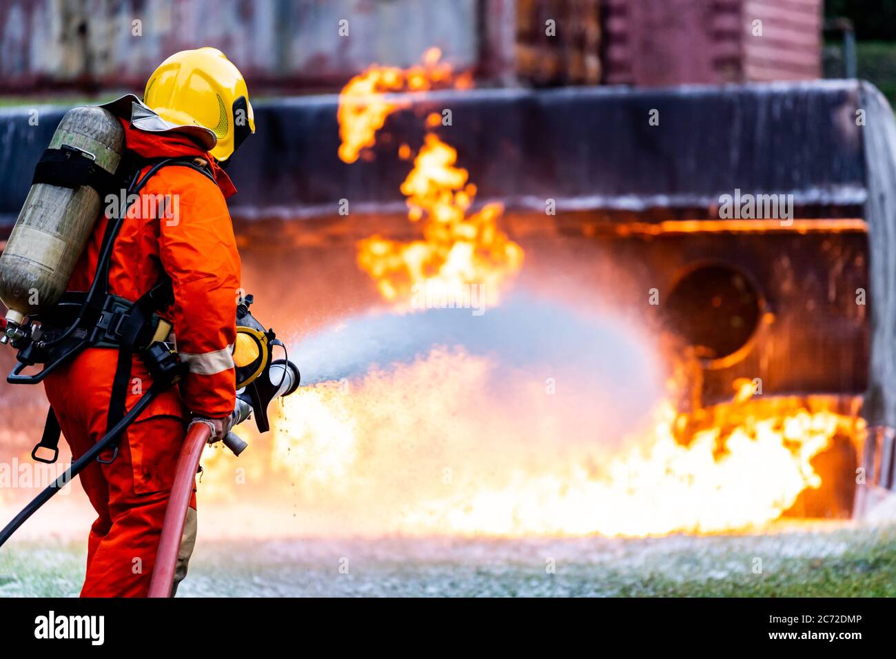 Feuerwehrmann mit chemischen Schaum Feuerlöscher zur Bekämpfung mit der Feuerflamme von Öltanker LKW Unfall. Feuerwehrmann Sicherheit Katastrophenunfall Stockfoto