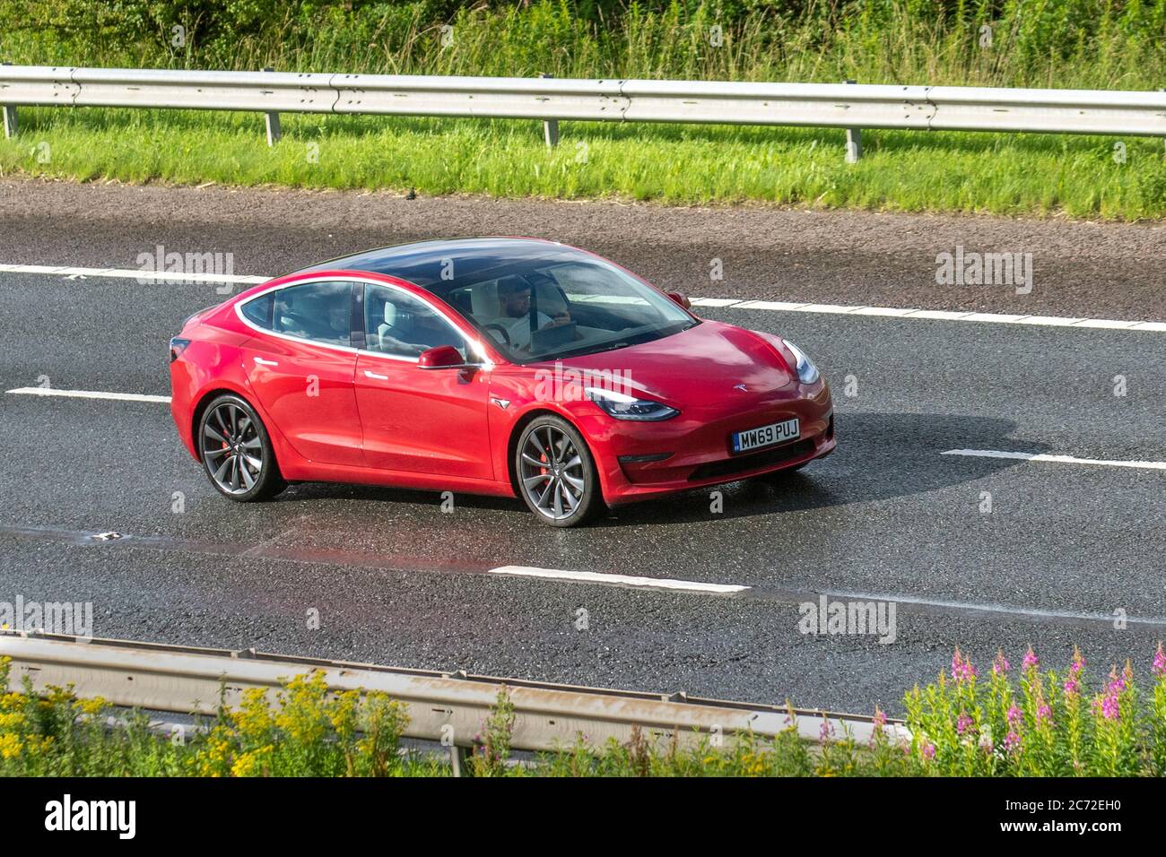 2019 rot Tesla Model 3 Performance AWD; Fahrzeuge mit Verkehrsbehinderungen, Fahrzeuge, die Fahrzeuge auf britischen Straßen fahren, Motoren, Fahrzeuge auf dem Autobahnnetz der M6. Stockfoto