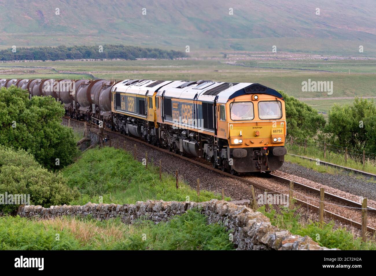 Ein abendlicher Güterzug, der von zwei Diesellokomotiven der Klasse 66 gezogen wird, fährt nach Norden nach Carlisle, Blea Moor, Settle-Carlisle Railway, North Yorkshire, UK Stockfoto
