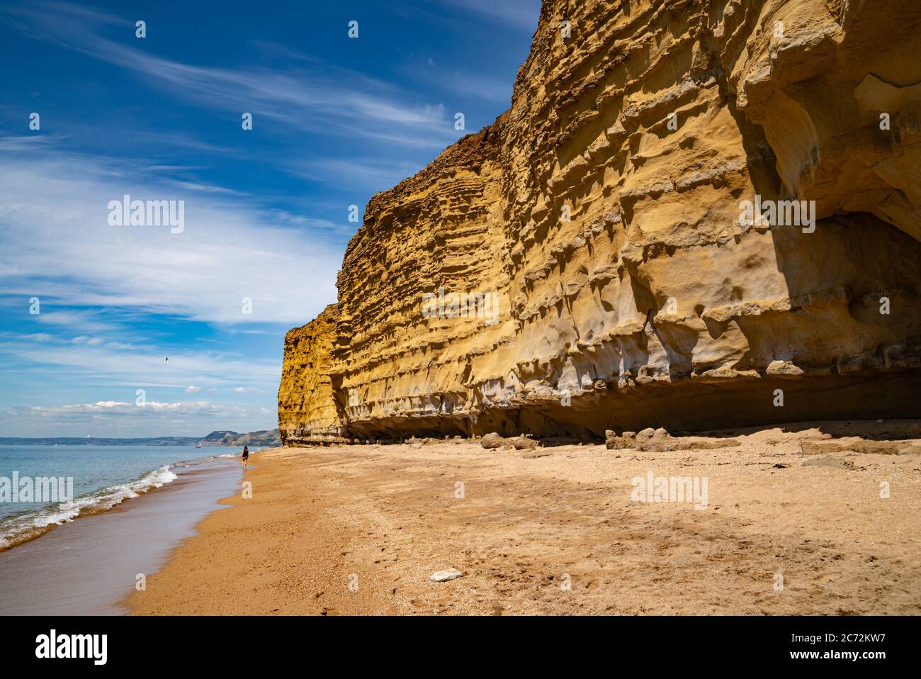 Meeresklippen bei Burton Bradstock, dem Beginn des Chesil-Strandes, an der Jurassic Coast von Dorset, Großbritannien mit blauem Himmel und weißen Wolken Stockfoto