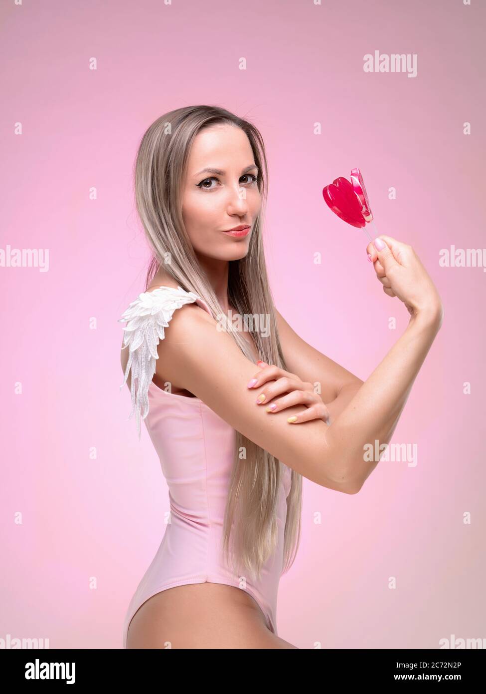 Schöne schlanke und fit Mädchen mit langen blonden Haaren in rosa Badeanzug. Leuchtende Haut Stockfoto