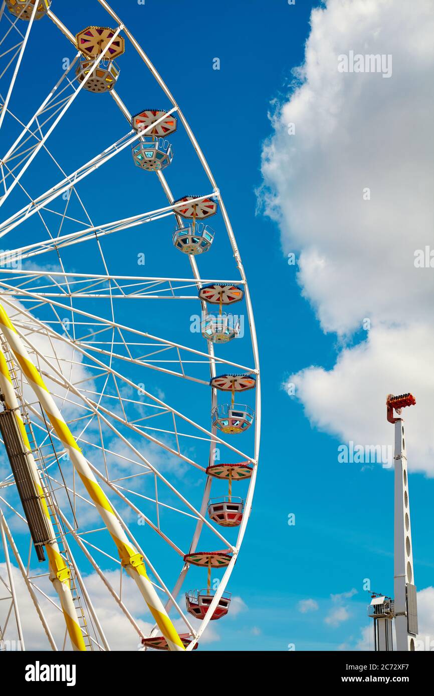 Riesenrad an einem sonnigen Tag mit blauem Himmel und Wolken im Hintergrund. Stockfoto
