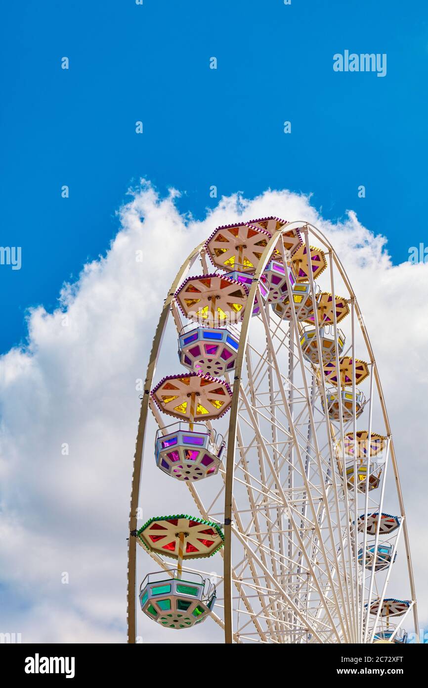 Riesenrad an einem sonnigen Tag mit blauem Himmel und Wolke im Hintergrund. Stockfoto