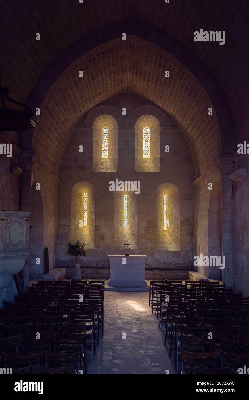 französisch romanischen Kirche Altar und hinterleuchtete Ost façade in der Morgen des Sommers 2020 - mit Stühlen im Vordergrund- Südwestlich von Frankreich Stockfoto