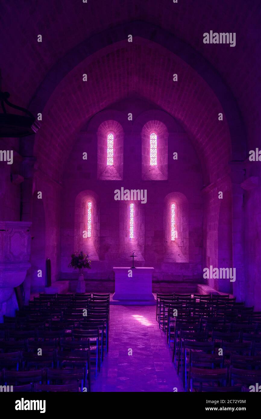 französisch romanischen Kirche Altar und hinterleuchtete Ost façade in der Morgen - mit Stühlen im Vordergrund - rosa und Blue Edit.- Südwest von Frankreich Stockfoto