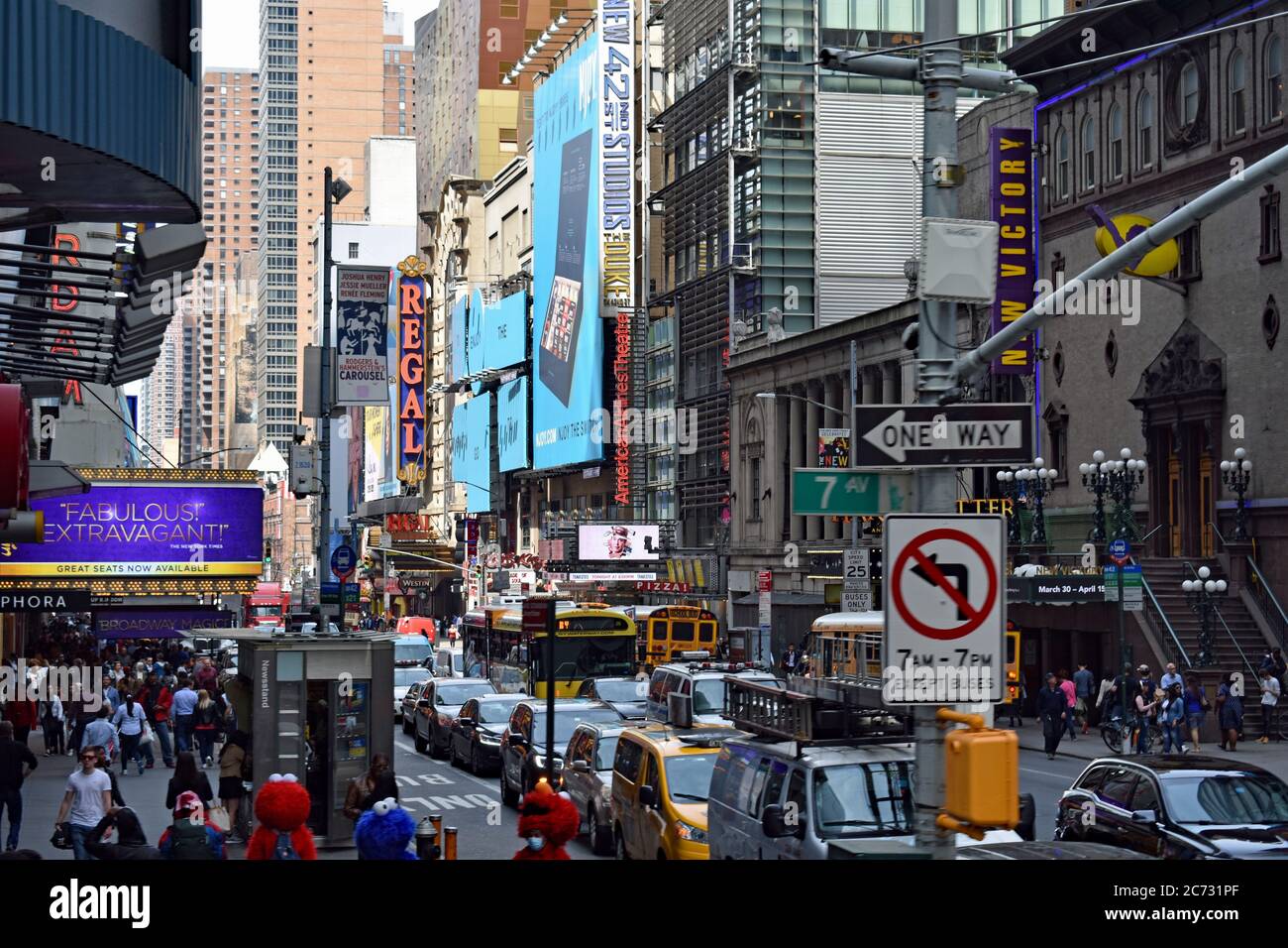 Blick auf die 42nd Street von der 7th Avenue. Autos stehen an der Kreuzung und Fußgänger sind auf dem Bürgersteig. Helle Lichter und Werbretter. Stockfoto