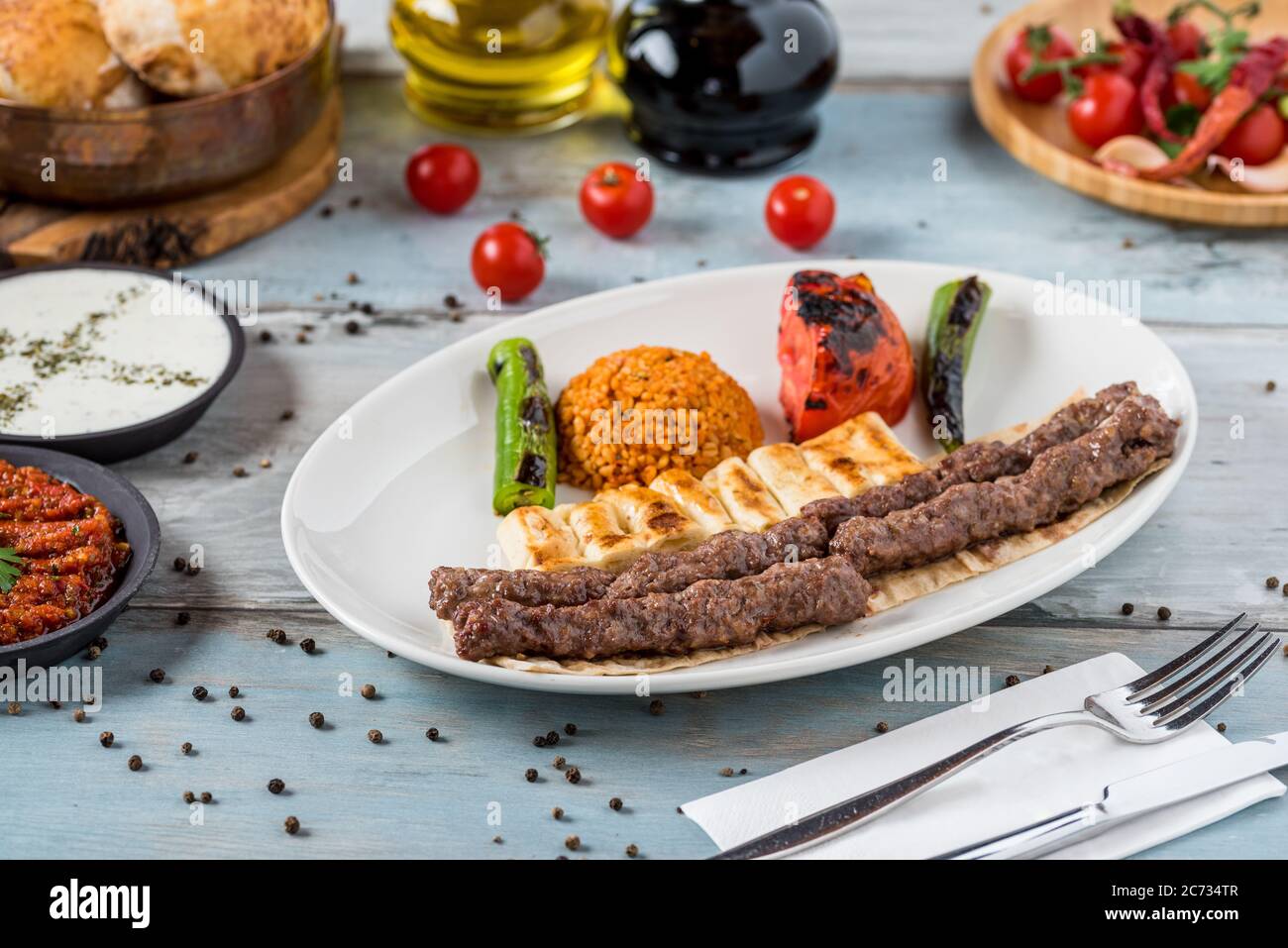 schisch-Fleischbällchen aus der türkischen Küche. Serviert mit weißem Teller auf Holztisch. Stockfoto