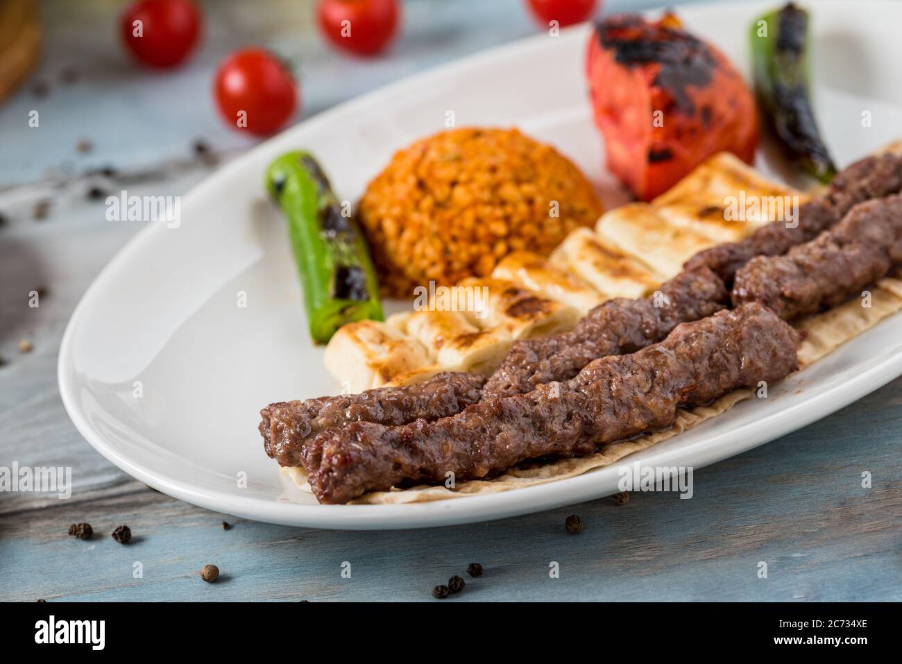 schisch-Fleischbällchen aus der türkischen Küche. Serviert mit weißem Teller auf Holztisch. Stockfoto