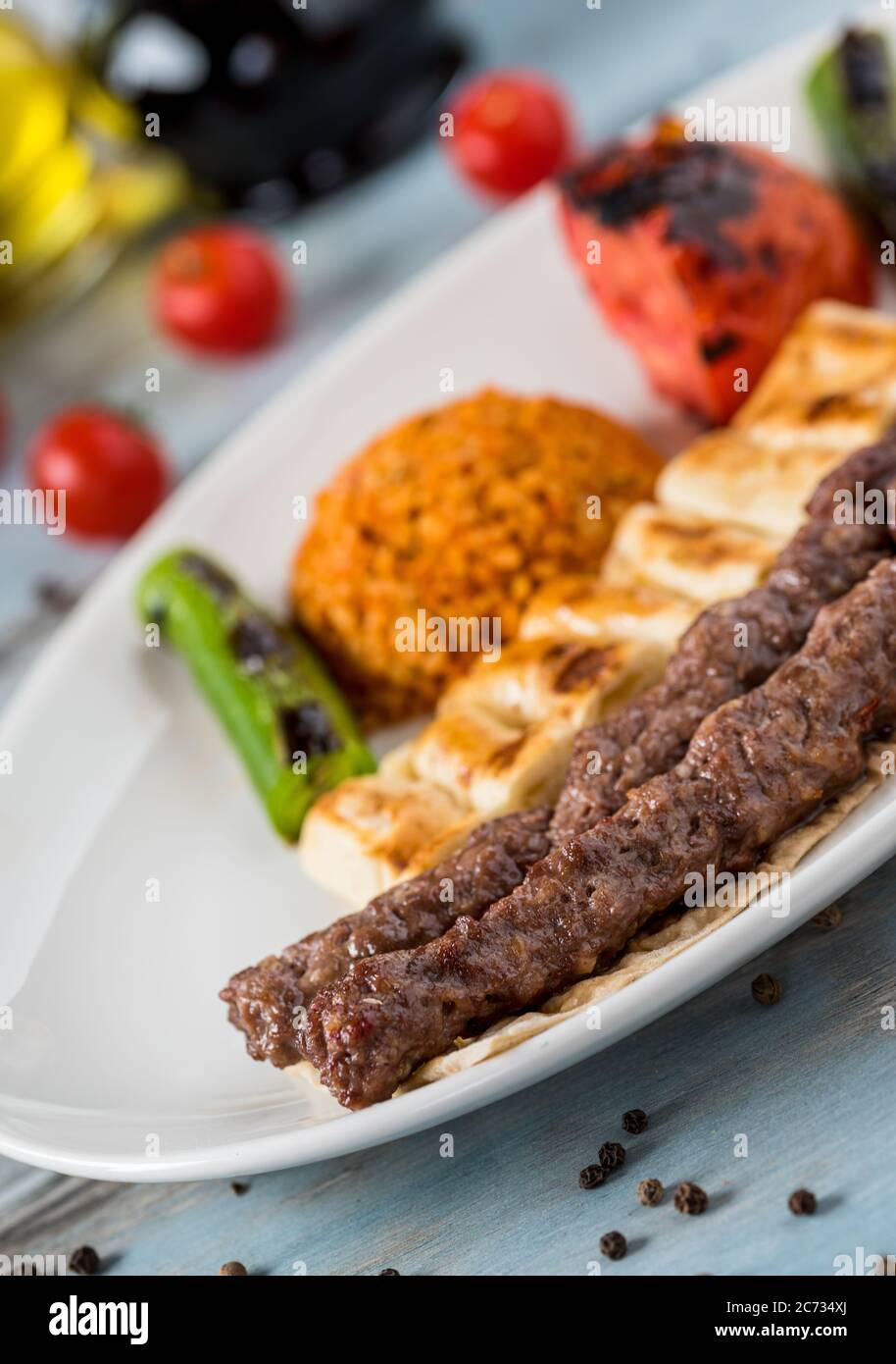 schisch-Fleischbällchen aus der türkischen Küche. Serviert mit weißem Teller auf Holztisch. Stockfoto