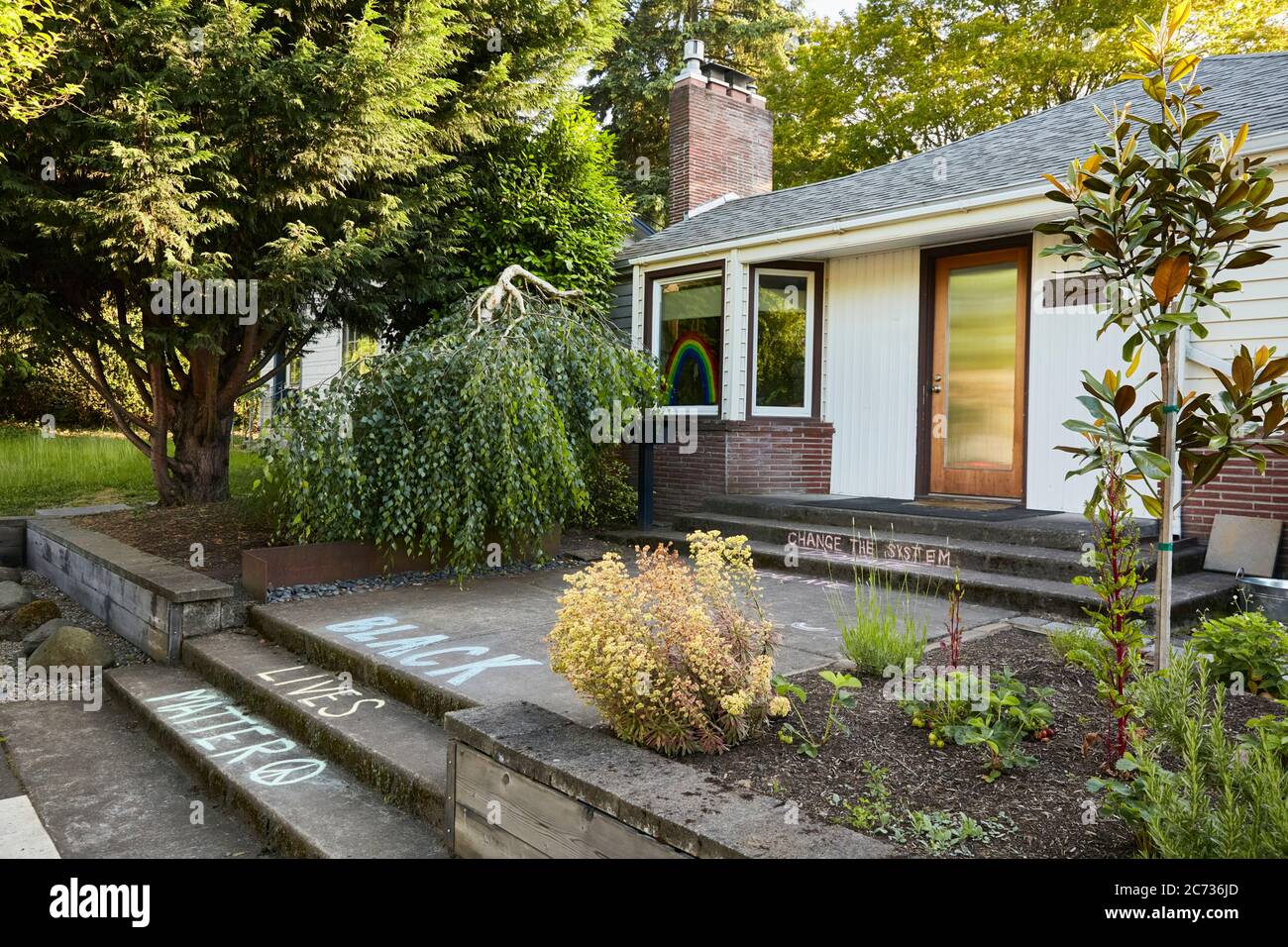 Portland, Oregon, USA - 2. Juni 2020: Seitenansicht eines Hauses im Stil der Mitte des Jahrhunderts mit dem Spruch "Black Lives Matter", der in Kreide auf der Vorderseite des hauses geschrieben wurde Stockfoto