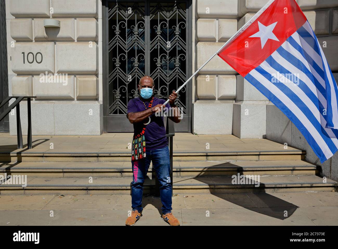 Unilever HQ - London (UK), Juli 11 2020: Ein Mann mit der West Papua Flagge schließt sich dem Protest gegen Unilever.Unilever werden der Zerstörung der beschuldigt Stockfoto