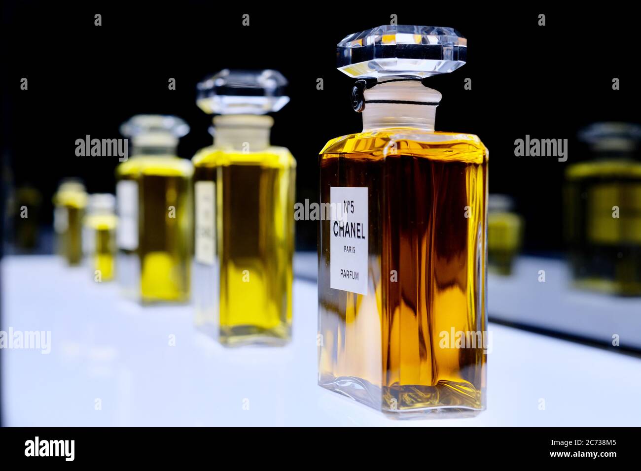 Nahaufnahme Flaschen des berühmten NO.5 Chanel Parfums auf weißem glänzenden Brett. Perspektivische Ansicht der Chanel parfum-Kollektion Nummer fünf. Stockfoto