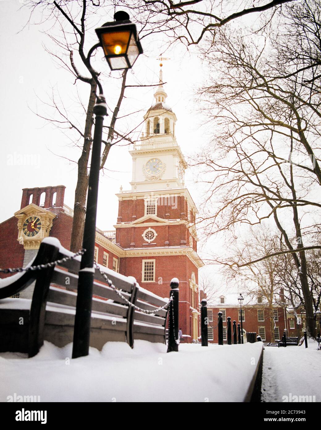 1970ER WINTER SZENE DER UNABHÄNGIGKEIT HALLE NATIONAL HISTORISCHEN PARK PHILADELPHIA PENNSYLVANIA USA - KP2401 HAR001 HARS AUSSEN NIEDRIGEN WINKEL PA PARKS 1776 KRIEG DER UNABHÄNGIGKEIT IMMOBILIEN COMMONWEALTH-STRUKTUREN KEYSTONE STAATSGEBÄUDE REVOLTE STAATSHAUS AMERICAN REVOLUTIONARY WAR NATIONAL PARK WINTERLICHE 1770ER KOLONIEN LAMPPOST NATIONALPARK SERVICE STADT BRÜDERLICH ICH LIEBE DAS HAR001 OLD FASHIONED SPIRE Stockfoto