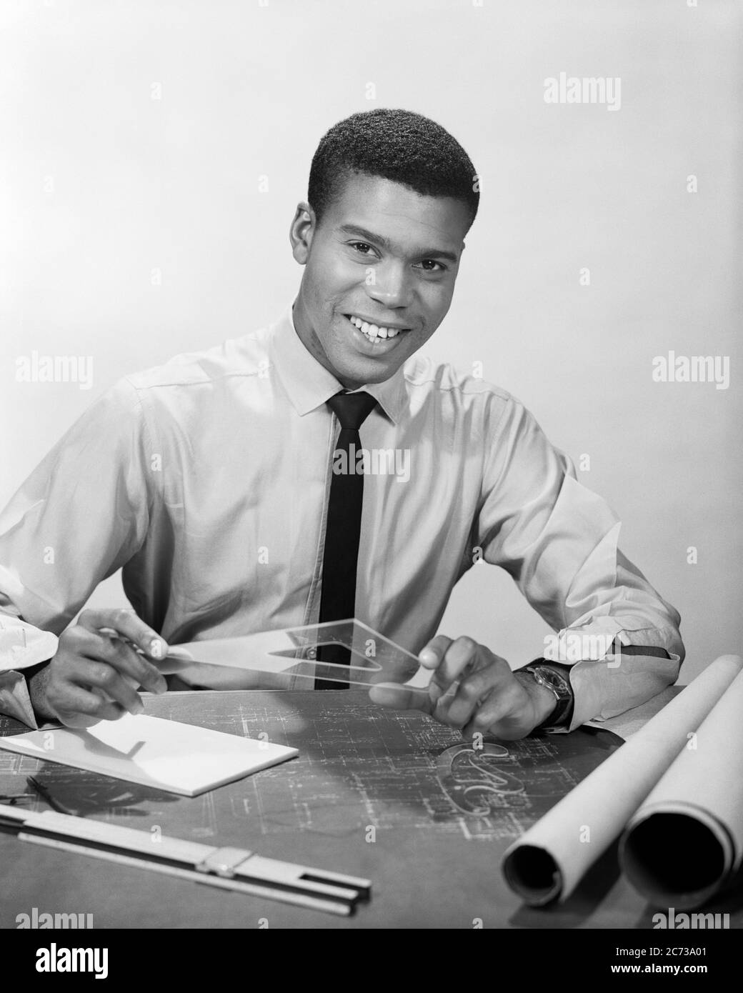 1950S 1960S SMILING AFRICAN-AMERICAN MAN WORKING ON DRAFTING BLUEPRINTS ARCHITECT DRAFTSMAN - N295 HAR001 HARS COPY SPACE HALF-LENGTH PERSONS EMÄNES ARCHITECT BERUF CONFIDENCE BLUEPRINTS B&W AUGE KONTAKT ZIELE GESCHICKLICHKEIT BERUF STRUKTUR GLÜCK FÄHIGKEITEN FRÖHLICH AFRO-AMERIKANER AFRO-AMERIKANER KARRIERE SCHWARZ ETHNIZITÄT ARBEIT STOLZ BESCHÄFTIGUNG BERUFE LÄCHELT GESTALTUNG PHANTASIE FREUDIG MITARBEITER KREATIVITÄT PRÄZISION TECHNISCHER JUNGER ERWACHSENER MANN SCHWARZ UND WEISS DRAFHER ZEICHNER HAR001 ARBEIT ALTMODISCHEN AFROAMERIKANER Stockfoto