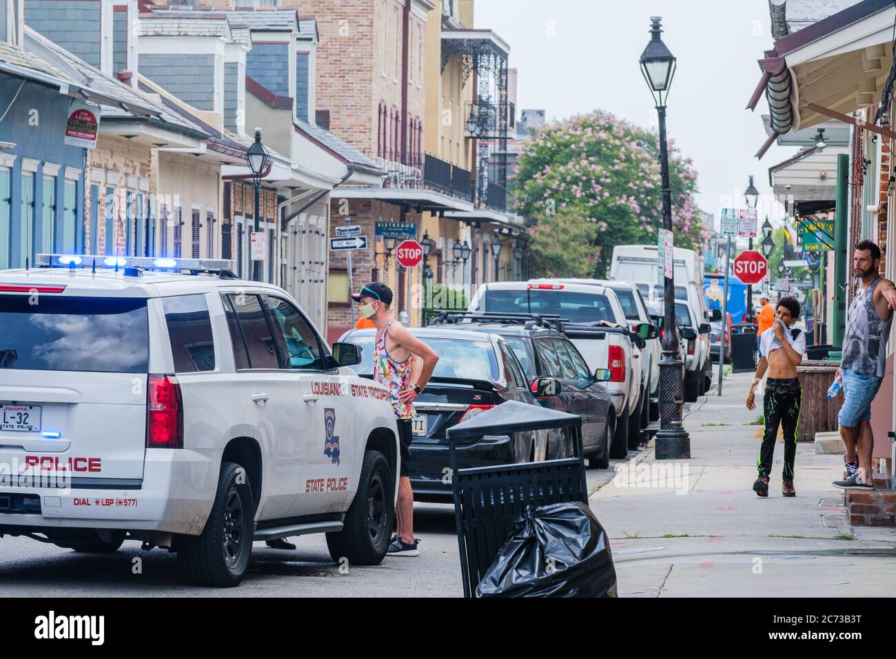 New Orleans, Louisiana/USA - 8. 7. 2020: Polizeiauto mit maskierten Verdächtigen und Zuschauern in Handschellen im French Quarter Stockfoto