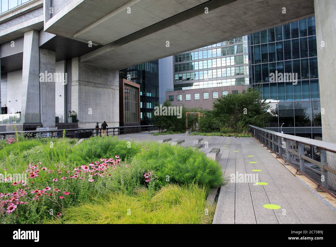 Der High Line Park in Manhattan wird am 16. Juli wieder für die Öffentlichkeit geöffnet. Die Kapazität ist begrenzt, die sozialen Abgrenzung ist geregelt und Besucher müssen Masken tragen. Grüne Kreise auf den Gehwegen helfen Besuchern, sechs Meter voneinander entfernt zu bleiben. Der Park war seit März während der Sperrung durch die Hornonavirus-Pandemie geschlossen. New York City, USA Juli 2020 Stockfoto