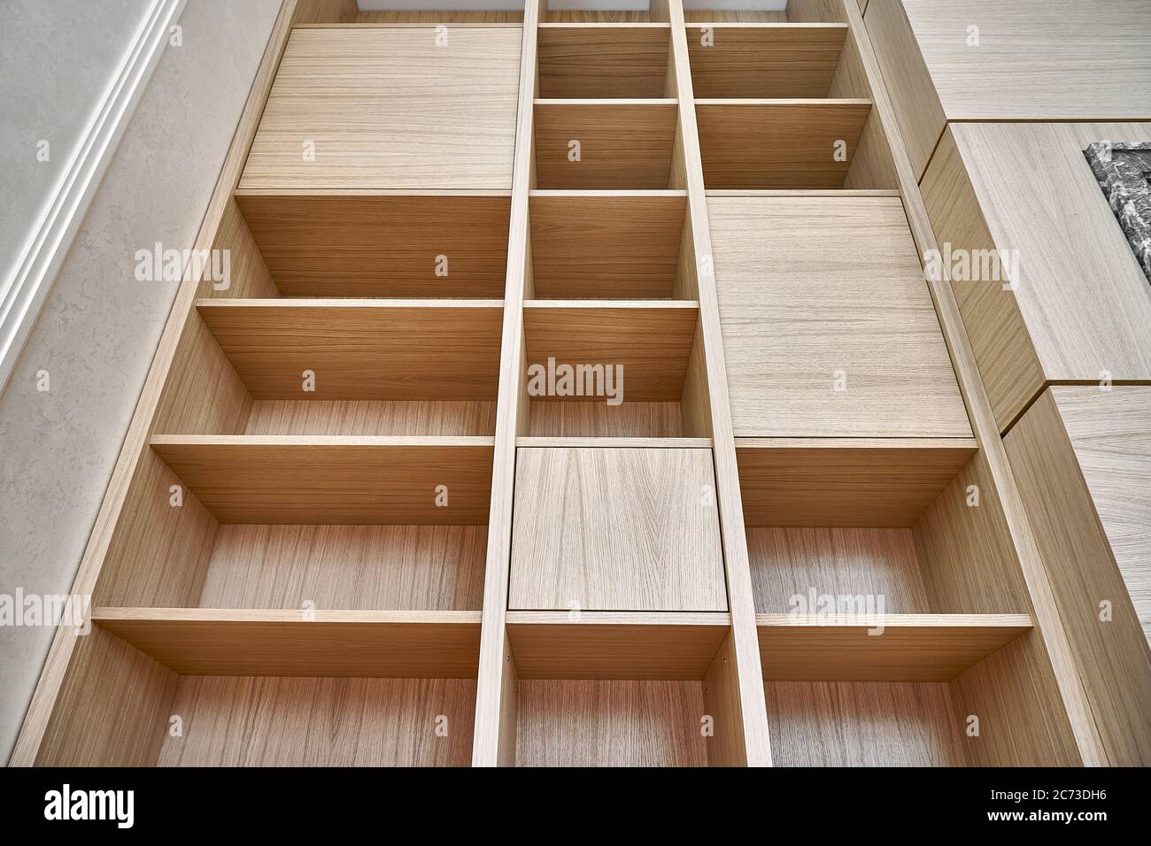 Bücherregale aus Holz. Holzbücherregale und Wandpaneele aus MDF furniert. Nahaufnahme Stockfoto