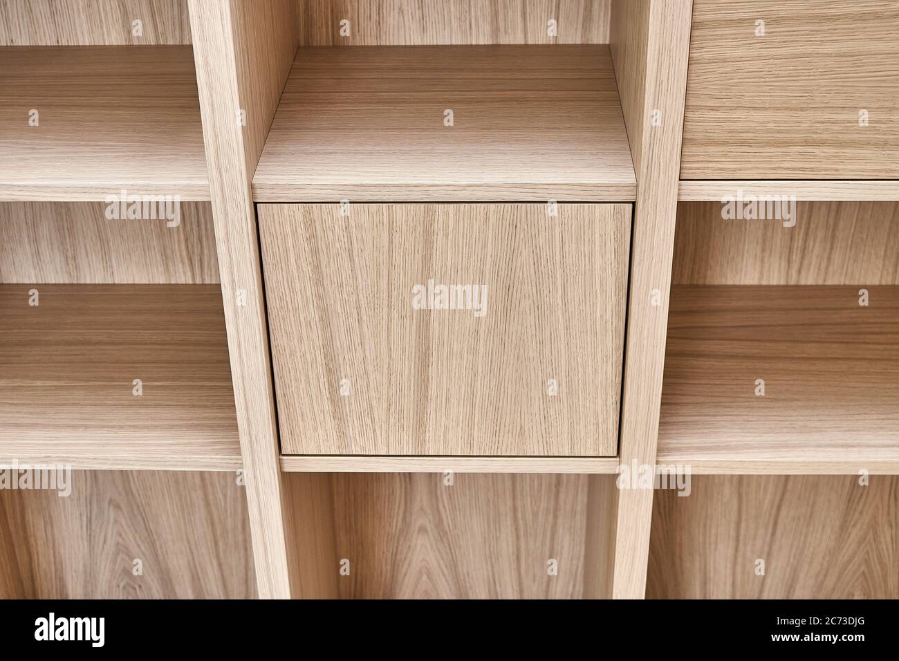 Bücherregale aus Holz. Holzbücherregale und Wandpaneele aus MDF furniert. Nahaufnahme Stockfoto