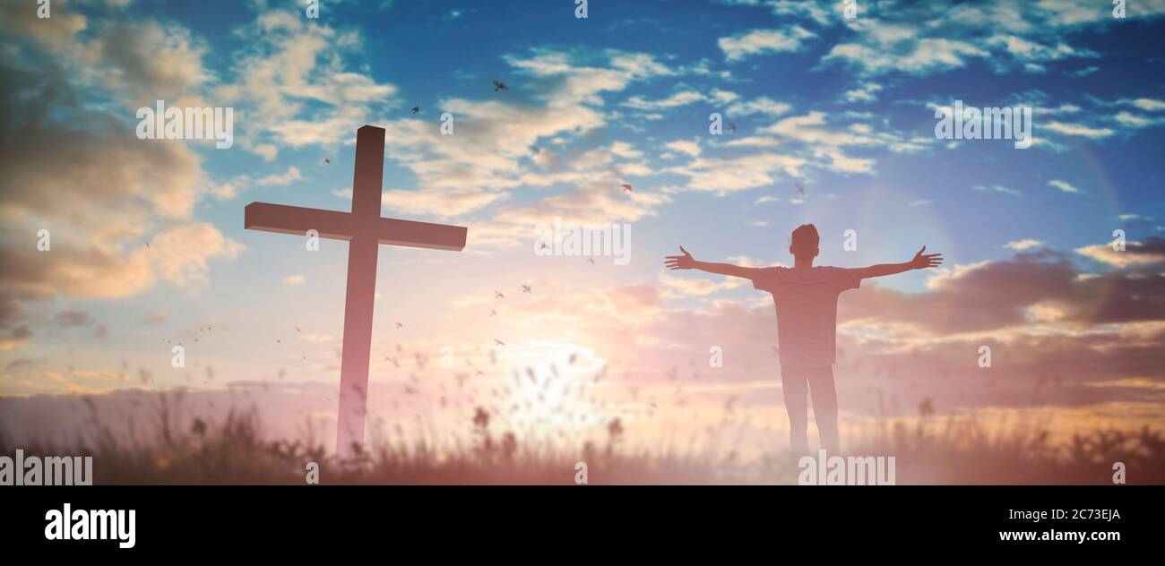 Glücklicher Mann erheben Hand Anbetung Gott in der Morgenansicht. Christlicher Geist Gebet Lob am karfreitag Kreuz Hintergrund. Männliche Selbstvertrauen Ermächtigung auf Stockfoto