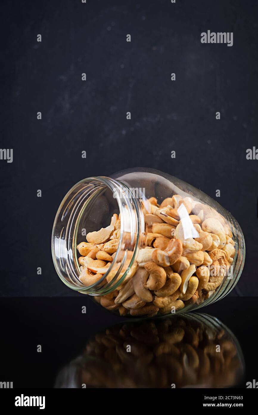 Cashewnüsse in einem Glas. Set Cashewnuss isoliert auf dunklem Hintergrund Stockfoto