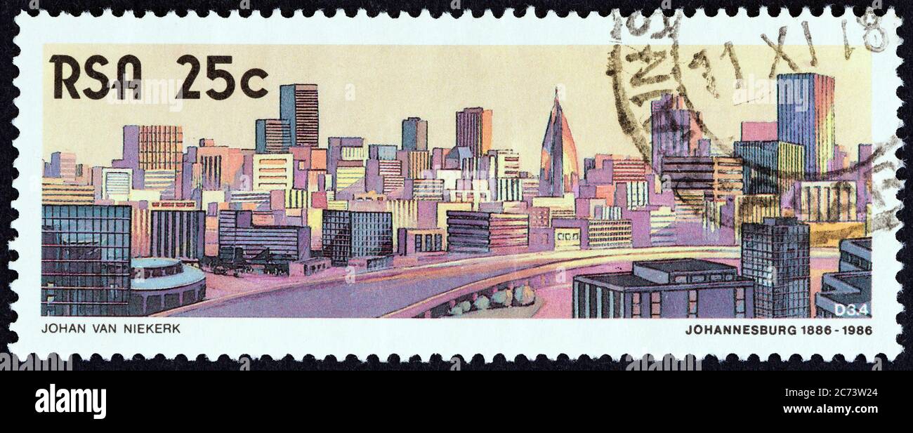 SÜDAFRIKA - UM 1986: Eine in Südafrika gedruckte Briefmarke aus der Ausgabe 'The 100th anniversary of Johannesburg' zeigt die Skyline von Johannesburg, 1986. Stockfoto