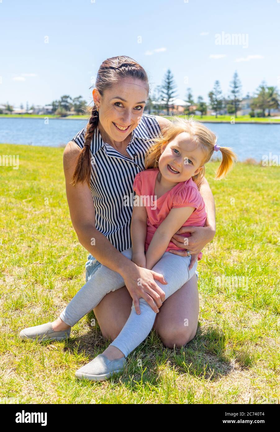 Positives Porträt von Mutter und Tochter, die gemeinsam am See Spaß haben. Nettes kleines Mädchen mit Mama im Park. Liebe, Familie Zeit, Mutterschaft, Kind Stockfoto